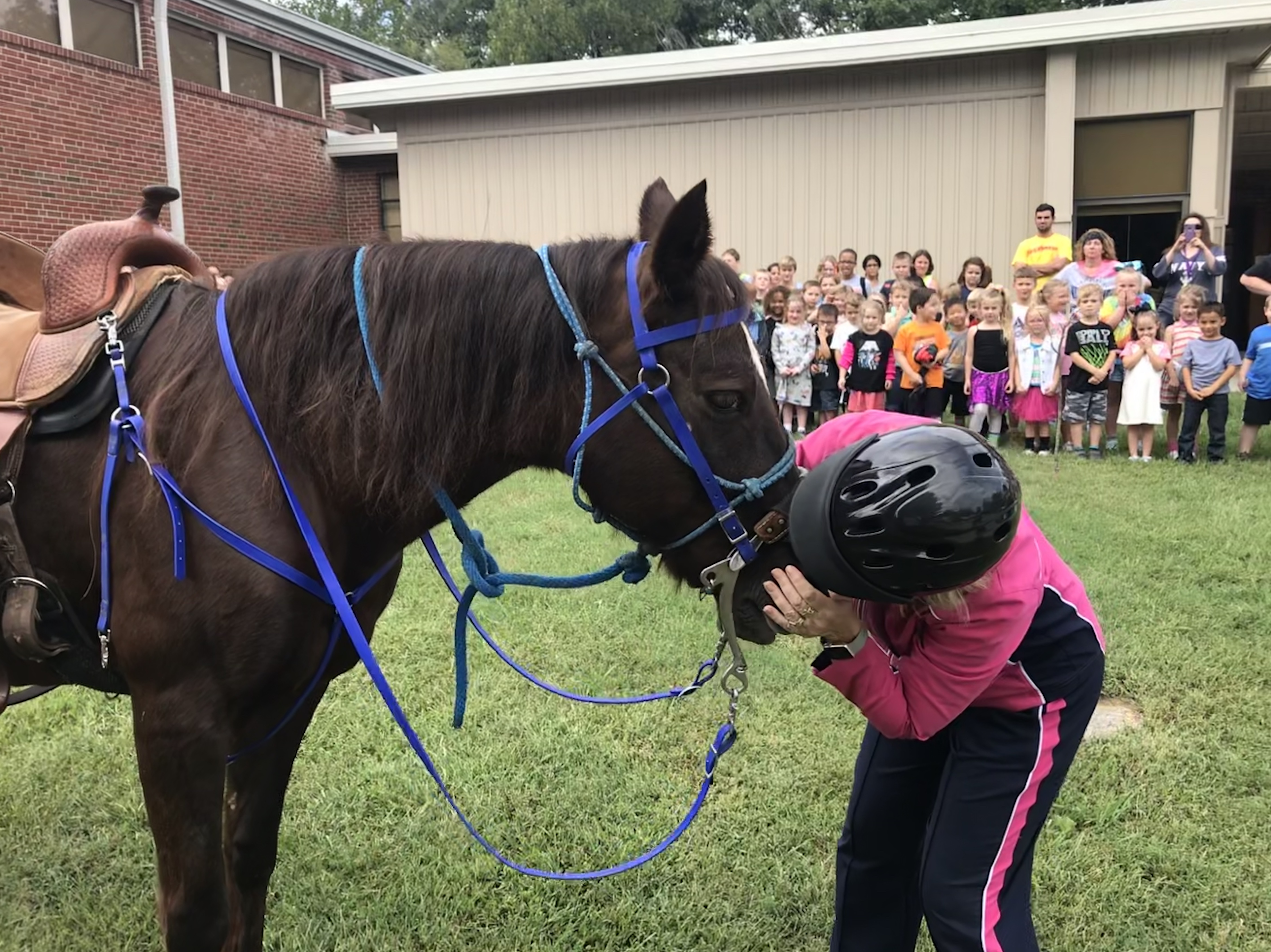New Hopewell Elementary principal Patricia Moore kisses a horse, as part of a coupon celebration on Sept. 28, 2018. 